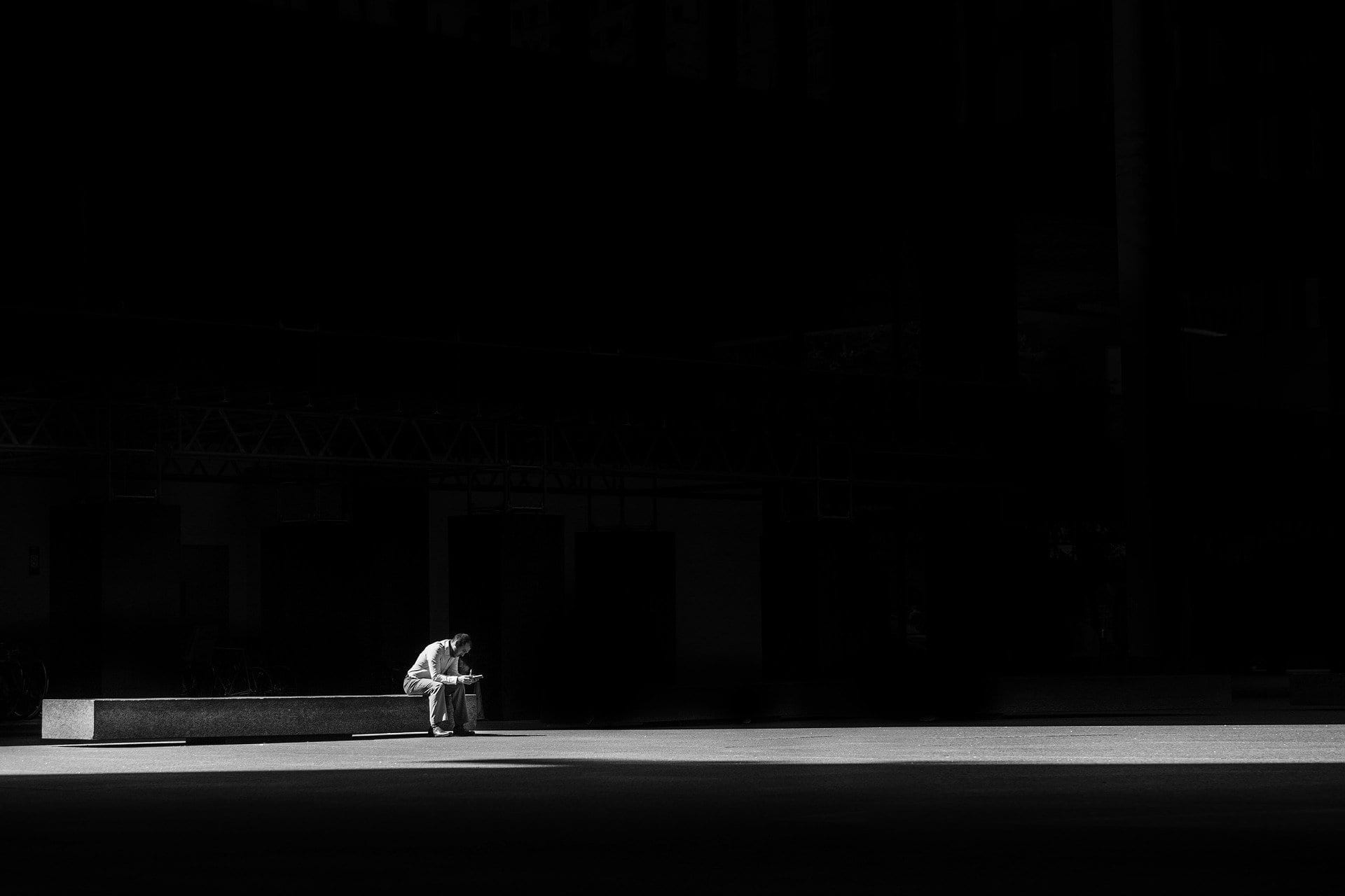 Man seated in prayer with dark background